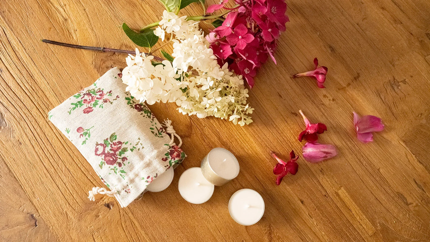 Bougies artisanales parfumées, fleurs et pochette en tissu sur table en bois, ambiance chaleureuse