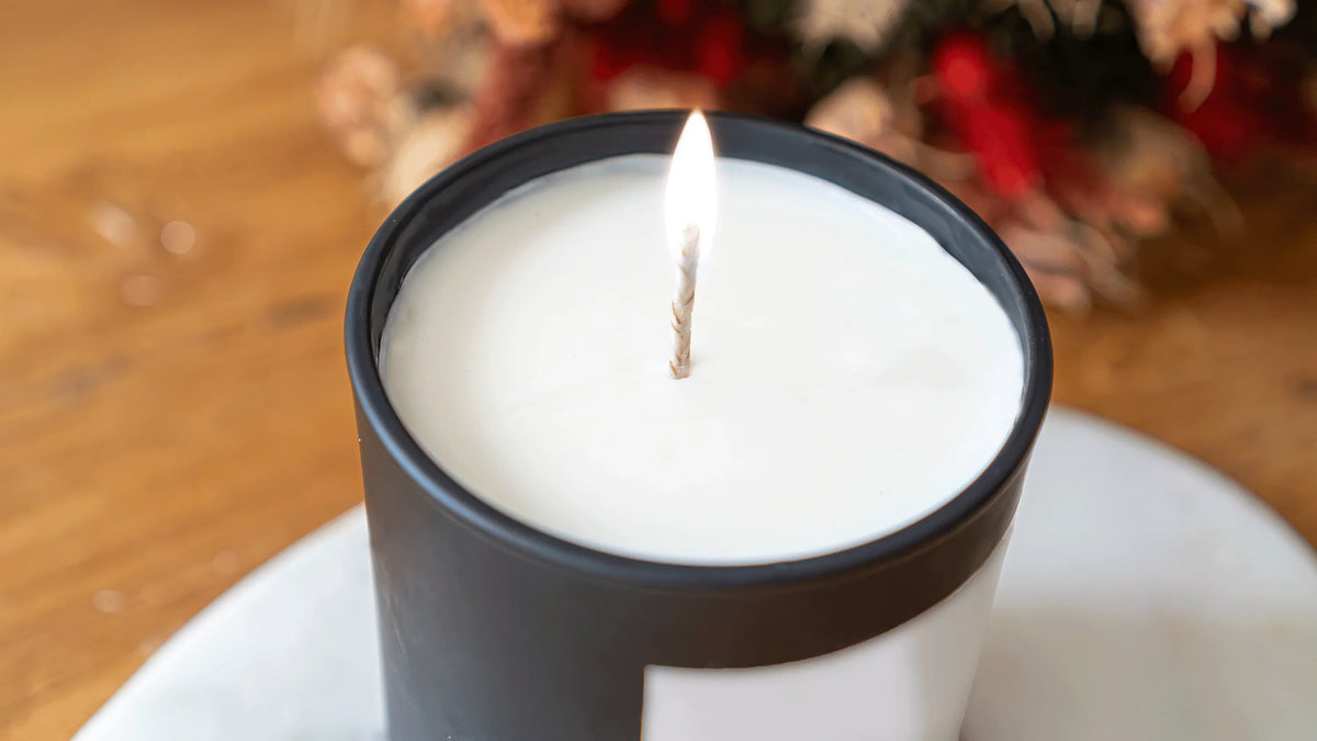 Bougie artisanale parfumée allumée dans un pot noir, ambiance chaleureuse, Amoureusement bougie