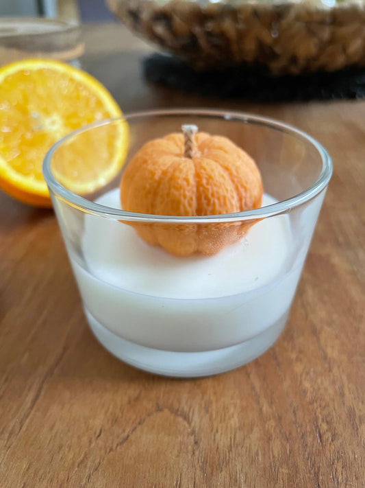 Bougie artisanale parfumée en forme de mandarine dans un verre, ambiance chaleureuse, Amoureusement bougie