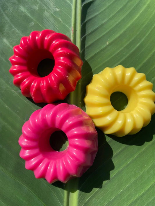 Bougies artisanales colorées en forme de couronne sur feuille verte, création Amoureusement bougie