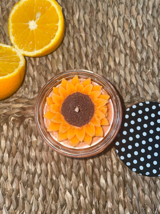 Bougie artisanale parfumée en forme de tournesol, tranches d’orange, sur tapis naturel